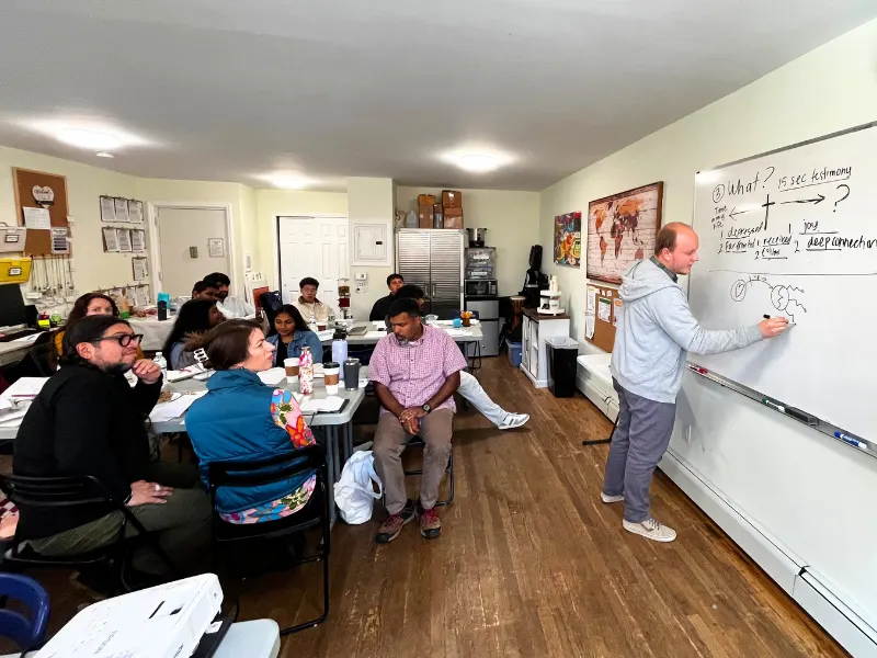 Person teaching at a whiteboard in a classroom setting
